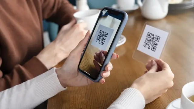 Advierten sobre la adulteración de los QR | Con un escaneo se puede autorizar copia de datos a ciberdelincuentes 3 cerrar manos escaneando codigo qr estafa quishing - 2